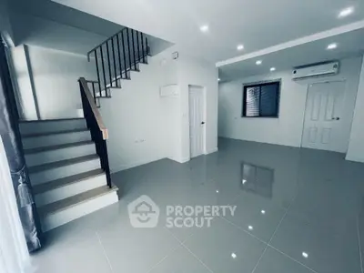 Spacious modern living room with sleek staircase and air conditioning