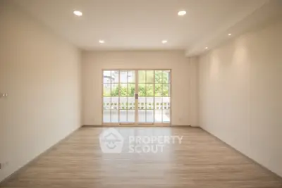 Spacious empty living room with large windows and wooden flooring