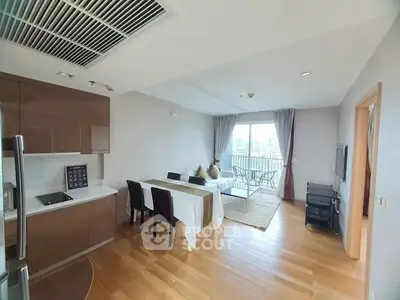 Modern open-plan living room with dining area and balcony view in a stylish apartment.