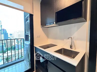 Modern kitchen with sleek cabinetry and city view from balcony