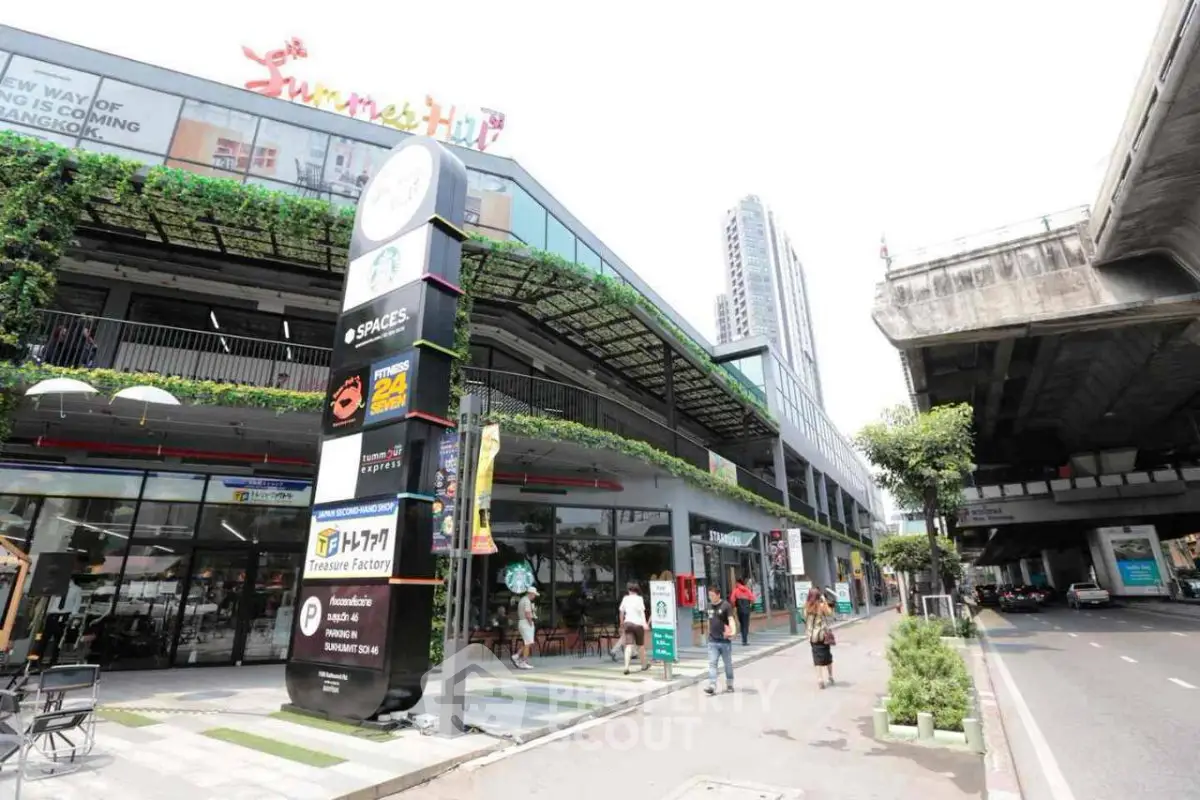 Modern commercial building with lush greenery and urban surroundings, ideal for retail or office space.