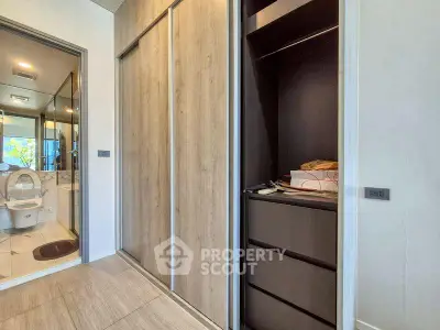 Modern apartment with sleek storage and bathroom view, featuring elegant wood finishes and contemporary design.