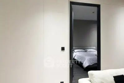 Modern bedroom view from living room with minimalist decor and neutral tones.
