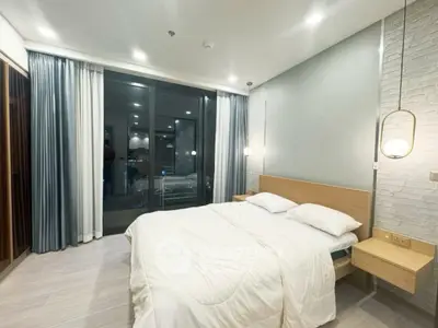 Modern bedroom with large window and stylish lighting in a contemporary apartment.