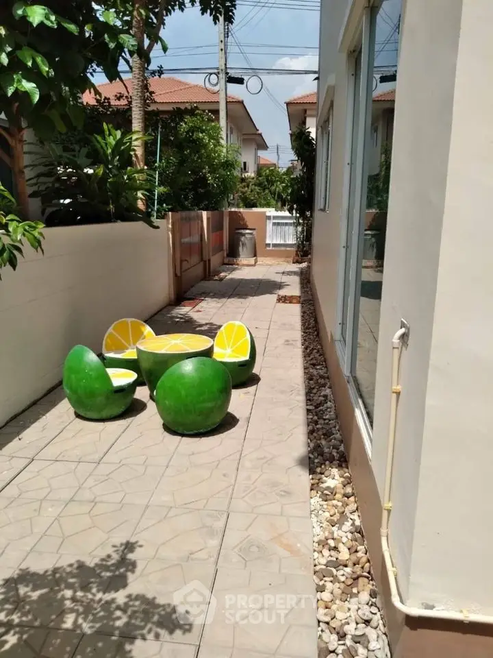 Charming outdoor patio with unique fruit-themed seating in a cozy residential area.