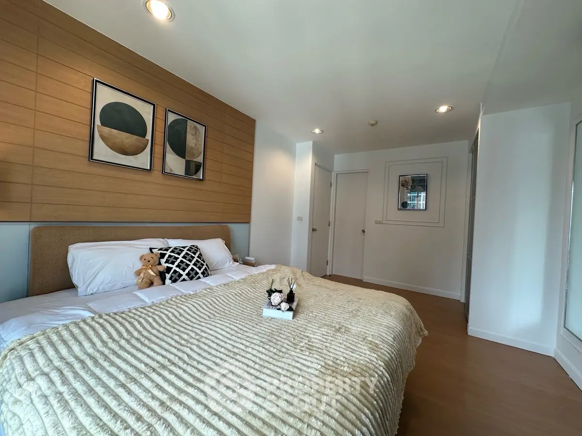 Modern bedroom with cozy decor and stylish artwork on the wall.