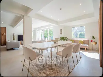 Spacious modern living and dining area with elegant furniture and large windows offering natural light.