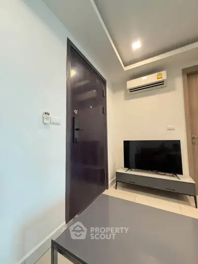 Modern living room with sleek furniture and air conditioning in a contemporary apartment.