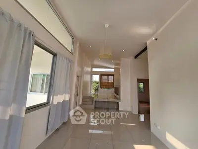 Spacious modern living room with high ceilings and large windows offering natural light.