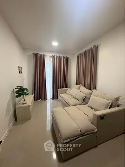 Cozy living room with plush sofa and elegant curtains, perfect for relaxation.