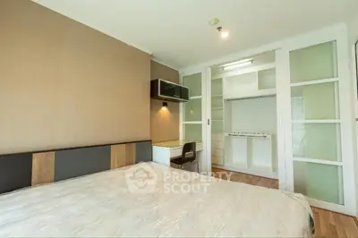 Spacious bedroom with modern design and built-in closet in a stylish apartment.