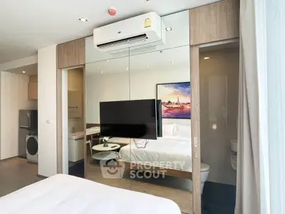 Modern bedroom with glass partition, featuring air conditioning and sleek decor.
