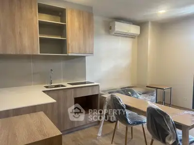 Modern kitchen with sleek wooden cabinets and dining area in a cozy apartment.