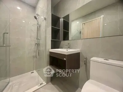 Modern bathroom with sleek design, glass shower, and elegant fixtures in a contemporary apartment.