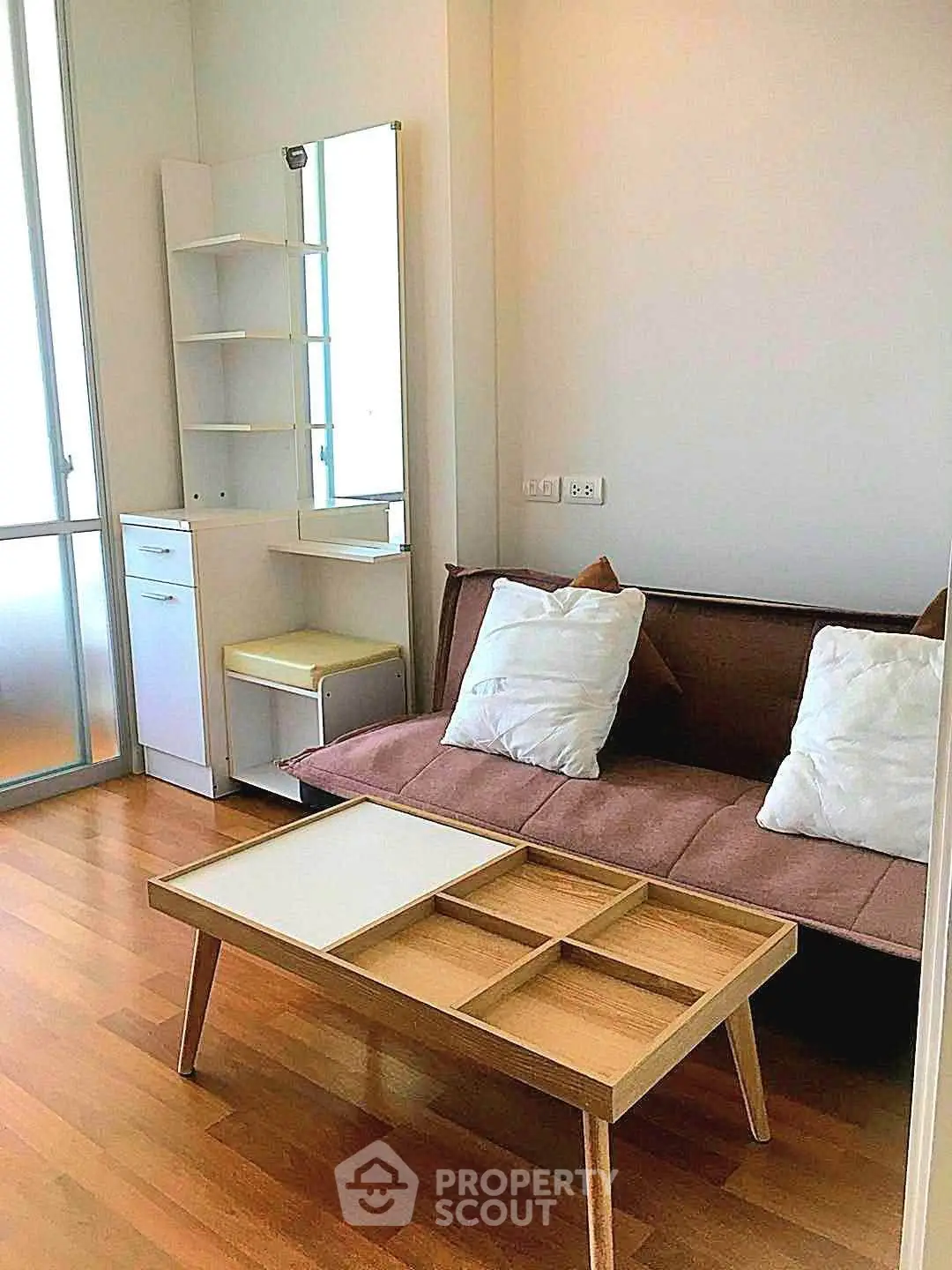Cozy living room with modern furniture and wooden flooring in a stylish apartment.