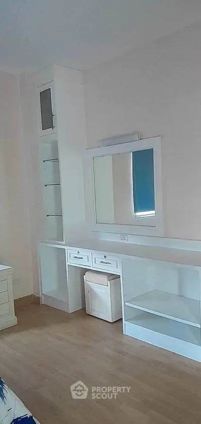 Spacious bedroom with built-in vanity and ample storage space