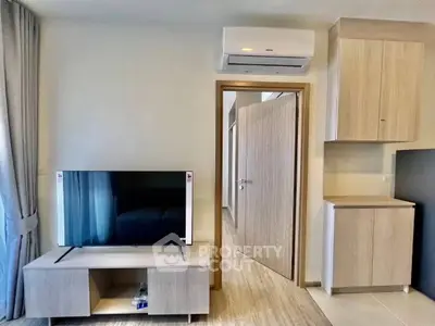 Modern living room with sleek TV setup and air conditioning in a stylish apartment.