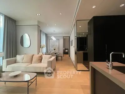 Luxurious modern living room with open kitchen, elegant decor, and natural light