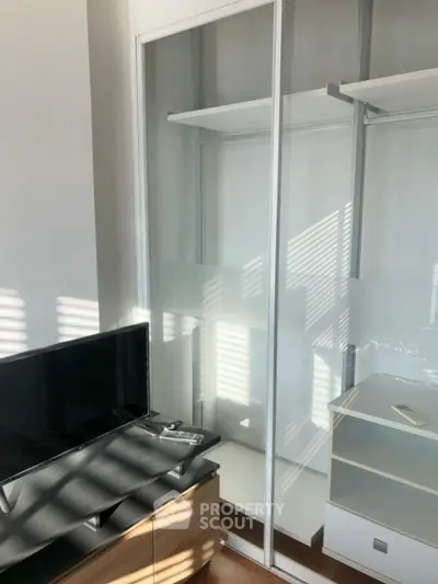 Modern bedroom with sleek wardrobe and TV stand, perfect for stylish living.
