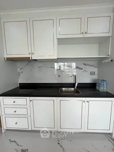 Modern kitchen with sleek white cabinets and marble backsplash