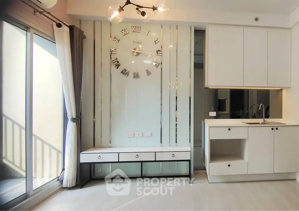 Modern living room with stylish wall clock and sleek kitchen area