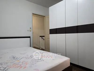 Modern bedroom with sleek wardrobe and floral bedspread