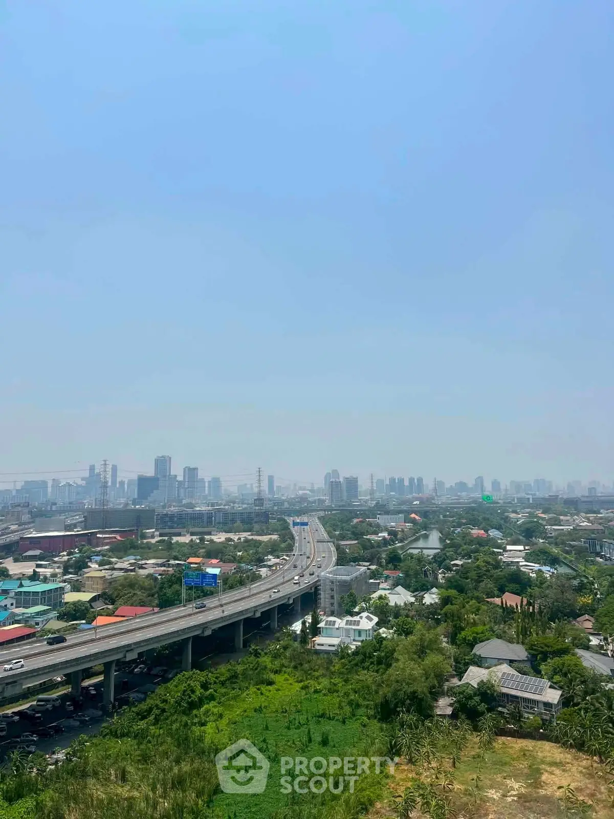 Stunning cityscape view from high-rise building overlooking urban skyline and highway.