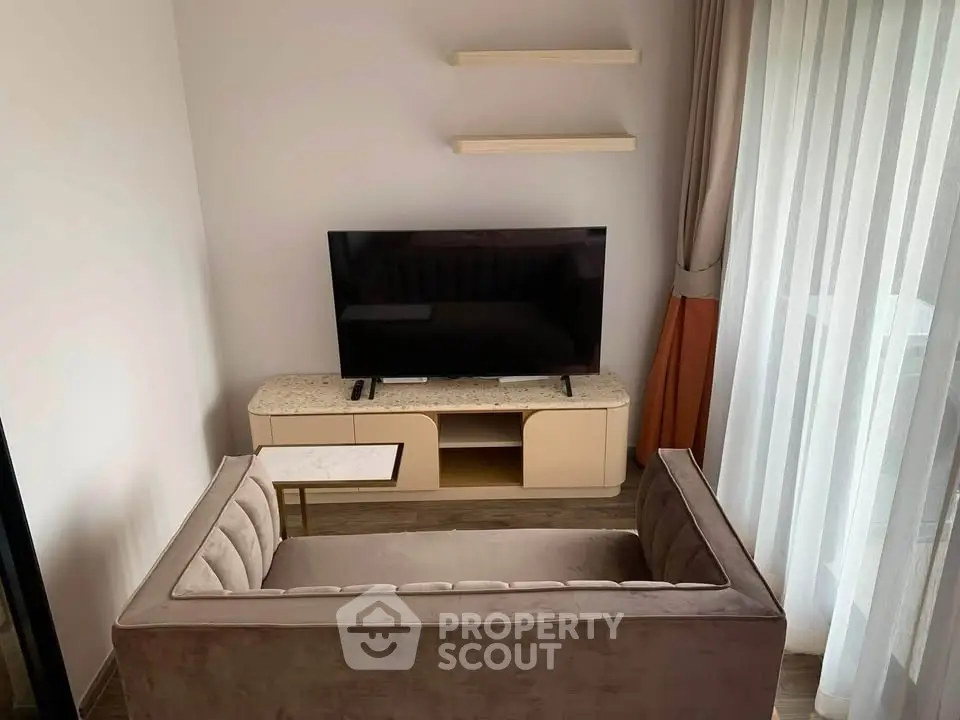 Modern living room with stylish sofa, TV, and elegant curtains, perfect for cozy relaxation.