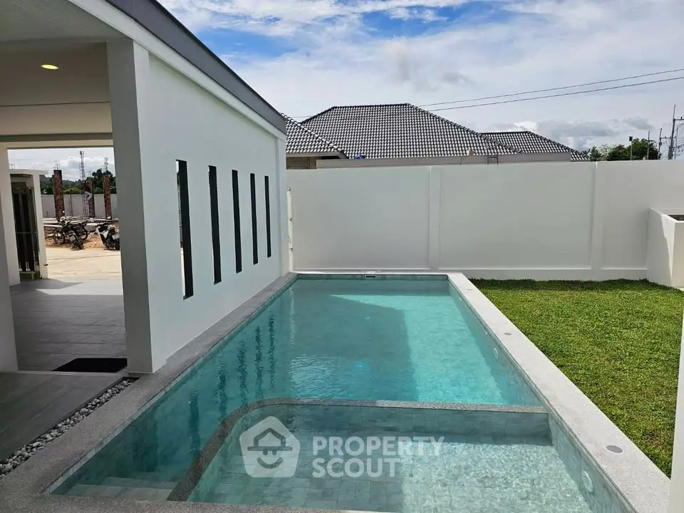Modern home with private pool and lush green lawn, perfect for relaxation and entertaining.