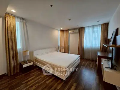 Spacious bedroom with modern decor and large windows in a luxury apartment.