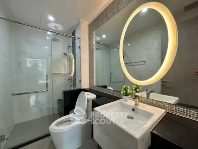 Modern bathroom with illuminated mirror and glass shower enclosure