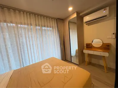 Modern bedroom with large window, air conditioning, and stylish vanity in a cozy apartment.