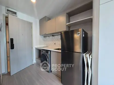 Modern compact kitchen with stainless steel fridge and washing machine