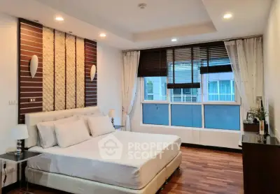 Spacious modern bedroom with elegant decor and large windows for natural light.