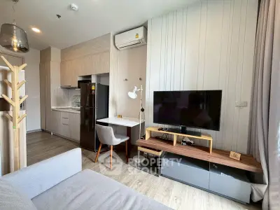Modern living room with sleek furniture and open kitchen layout in a stylish apartment.