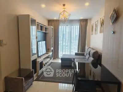 Modern living room with stylish decor and large window offering city views.