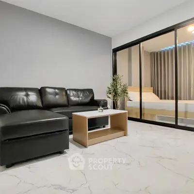Modern living room with sleek black leather sofa and marble flooring