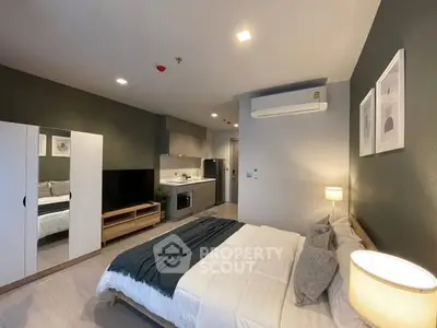Modern bedroom with stylish decor and open kitchen layout in a cozy apartment.