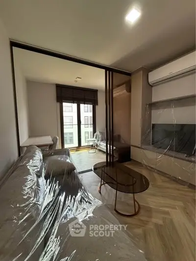 Modern living room with large windows, stylish furniture, and air conditioning, perfect for urban living.