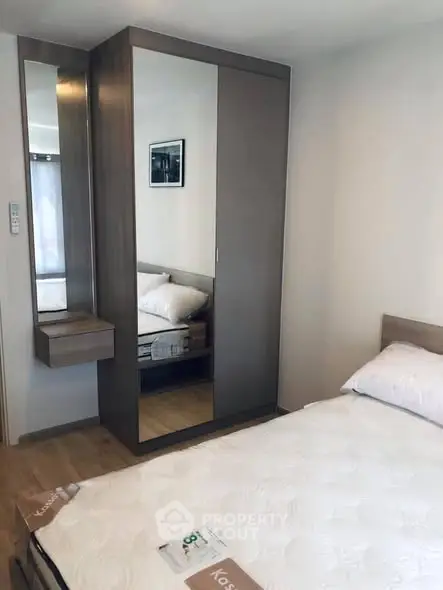 Modern bedroom with sleek wardrobe and cozy bed in stylish apartment.