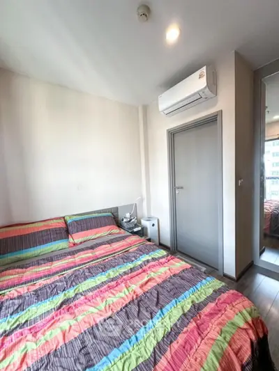 Cozy bedroom with colorful bedding and modern air conditioning unit
