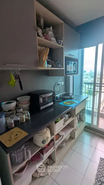 Cozy kitchen with open shelving and balcony view, featuring modern appliances and ample storage space.