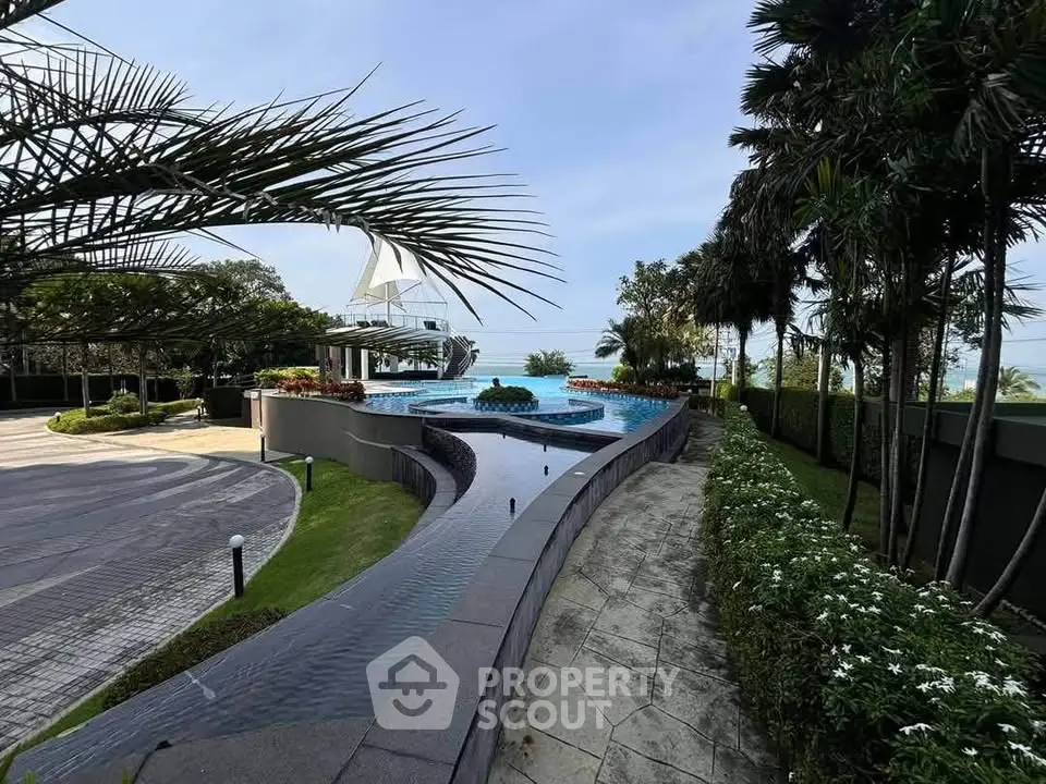 Luxurious outdoor pool area with stunning ocean view and lush greenery.