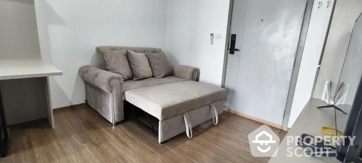 Modern living room with stylish sofa bed and wooden flooring, perfect for cozy urban living.