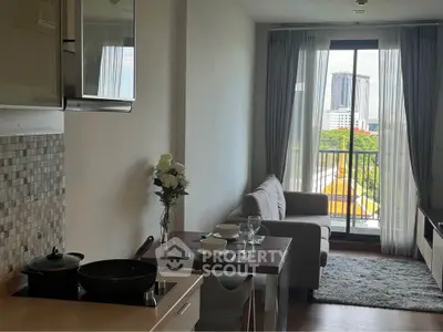 Modern apartment with open kitchen and cozy living area, featuring a balcony with city view.