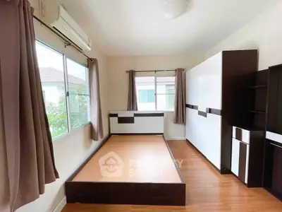 Spacious bedroom with modern furniture and large windows for natural light