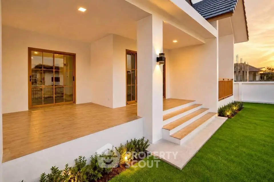 Stunning modern home exterior with elegant porch and lush green lawn at sunset.