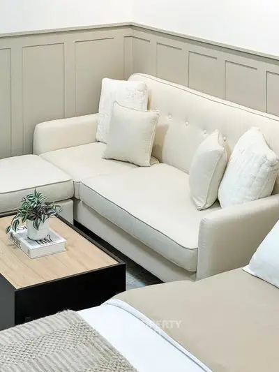 Cozy living room with beige sofa and modern decor, perfect for relaxation.