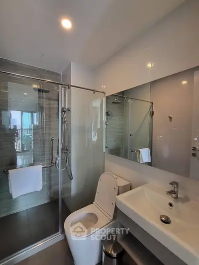 Modern bathroom with glass shower and sleek fixtures in a contemporary apartment.