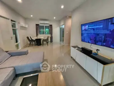 Spacious modern living room with sleek furniture and large TV, perfect for relaxation and entertainment.